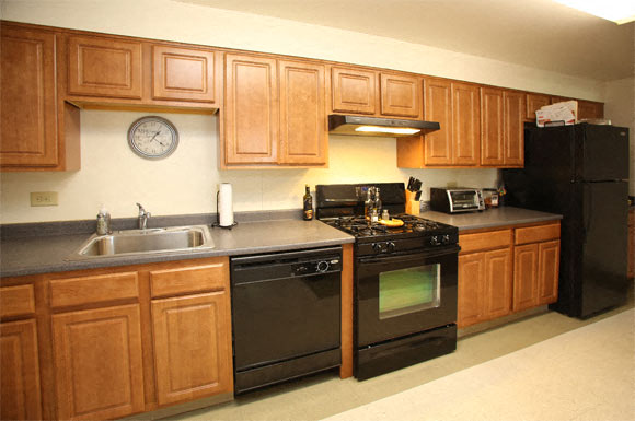 A kitchen with wooden cabinets and black appliances.
