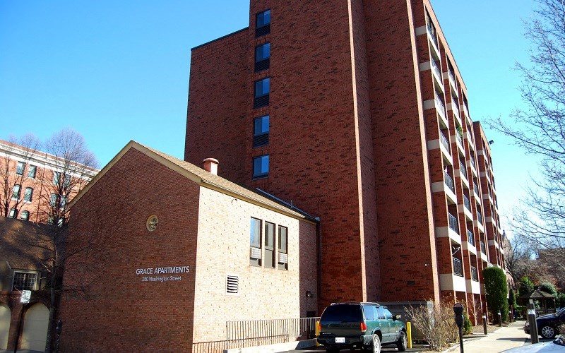 A brick building with a sign that says Grace Apartments.