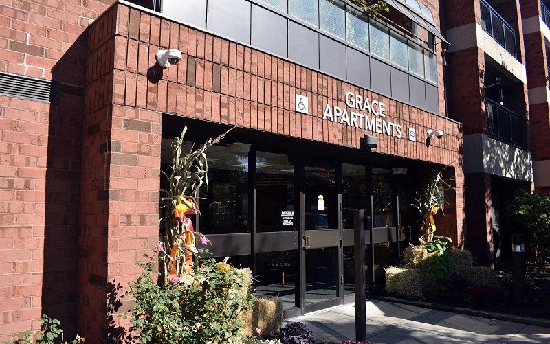 The front of a building with the words "Grace Apartments" on it.