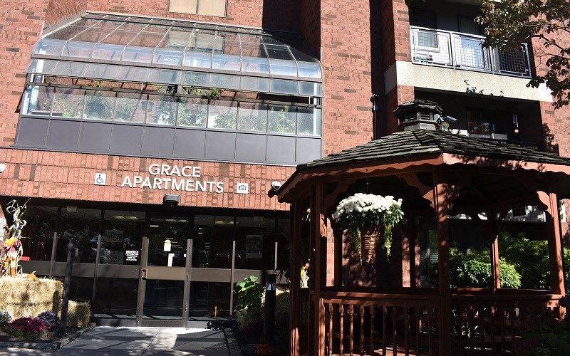 The front of the Grace Apartments building with a gazebo in front.