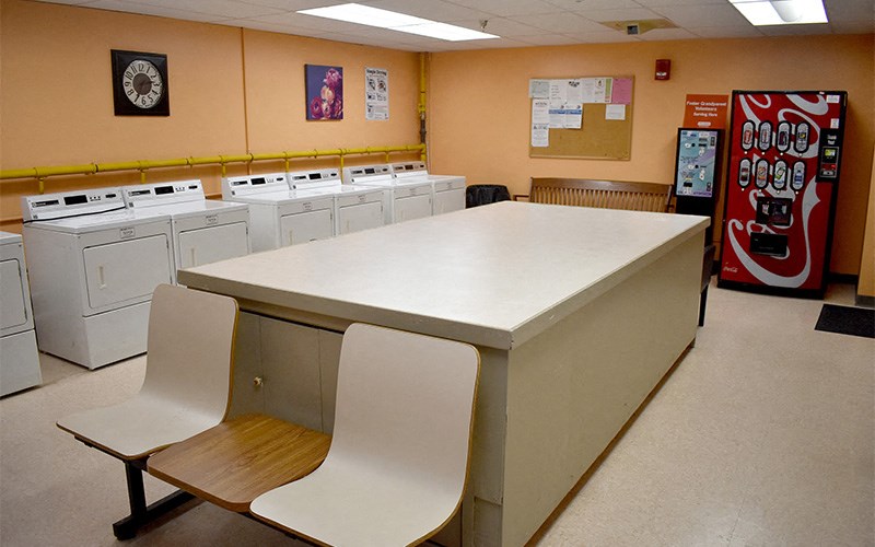 A laundromat with a row of washers and a vending machine.