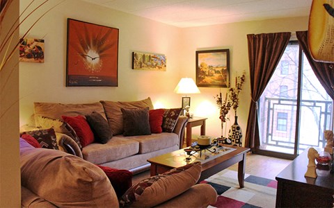 A living room with a couch, a coffee table, and a painting on the wall.