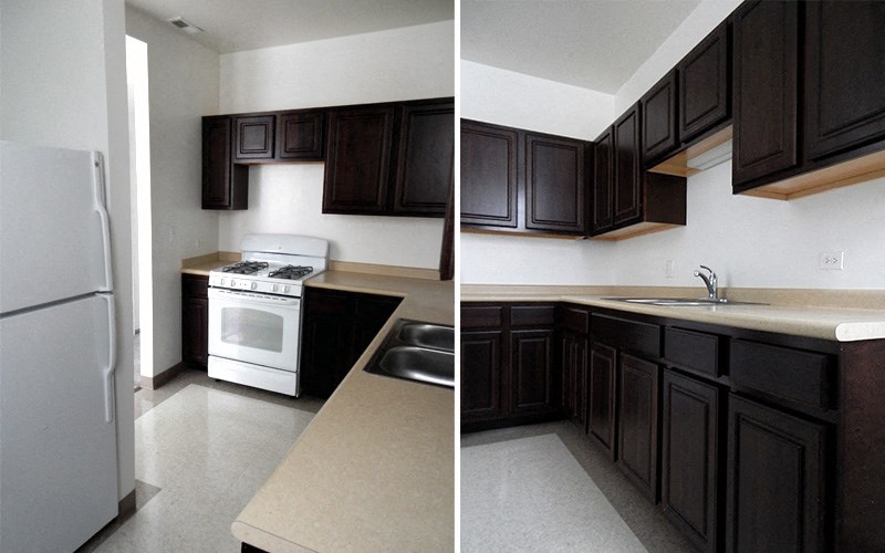 A kitchen with a white fridge and black cabinets.