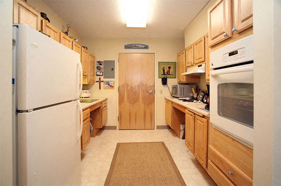 A kitchen with wooden cabinets and a white refrigerator.