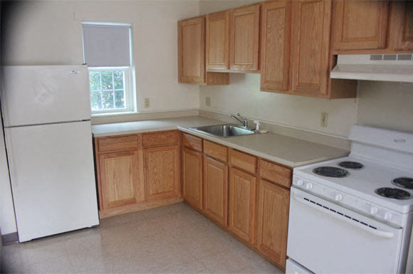 A kitchen with wooden cabinets and white appliances.