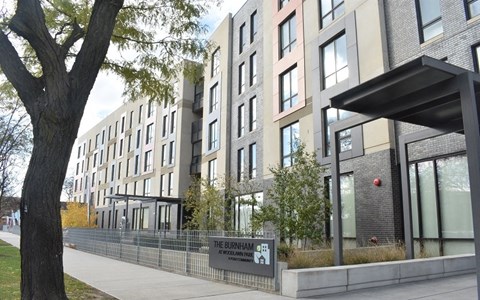 A modern apartment building named The Burnham is shown in the image.