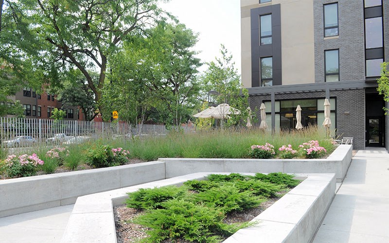 A modern building with a landscaped garden in front.