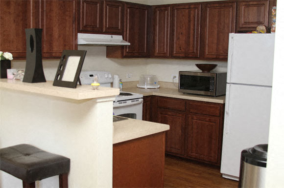A kitchen with brown cabinets and a white refrigerator.
