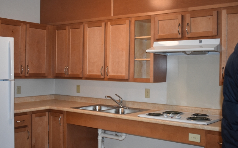 an empty kitchen with wooden cabinets and a stove and sink
