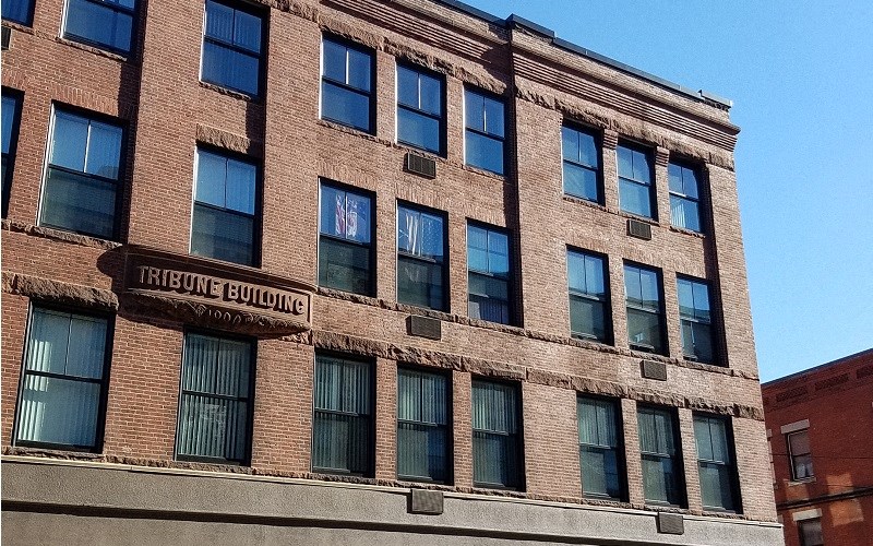 a large brick building with windows and a street sign