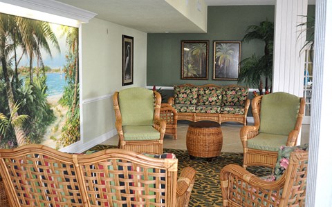 a living room with wicker furniture and a view of the ocean