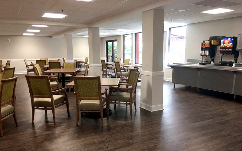 a dining room with tables and chairs and a vending machine