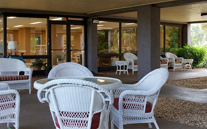 a patio with chairs and tables on a porch