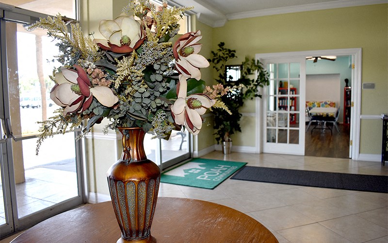 a vase filled with flowers on a table in a lobby