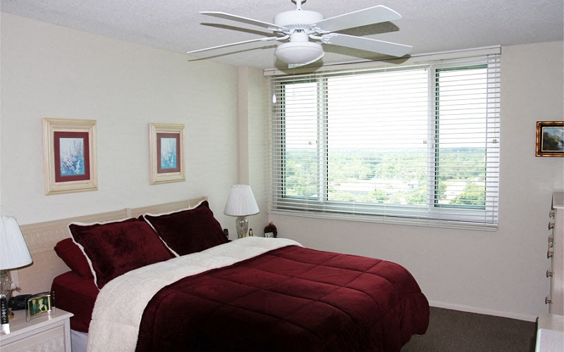 a bedroom with a bed and a ceiling fan and a window