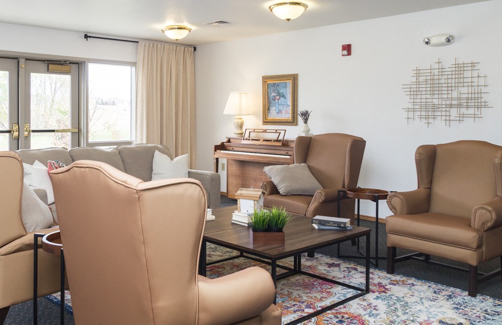 a living room with a couch and chairs and a piano