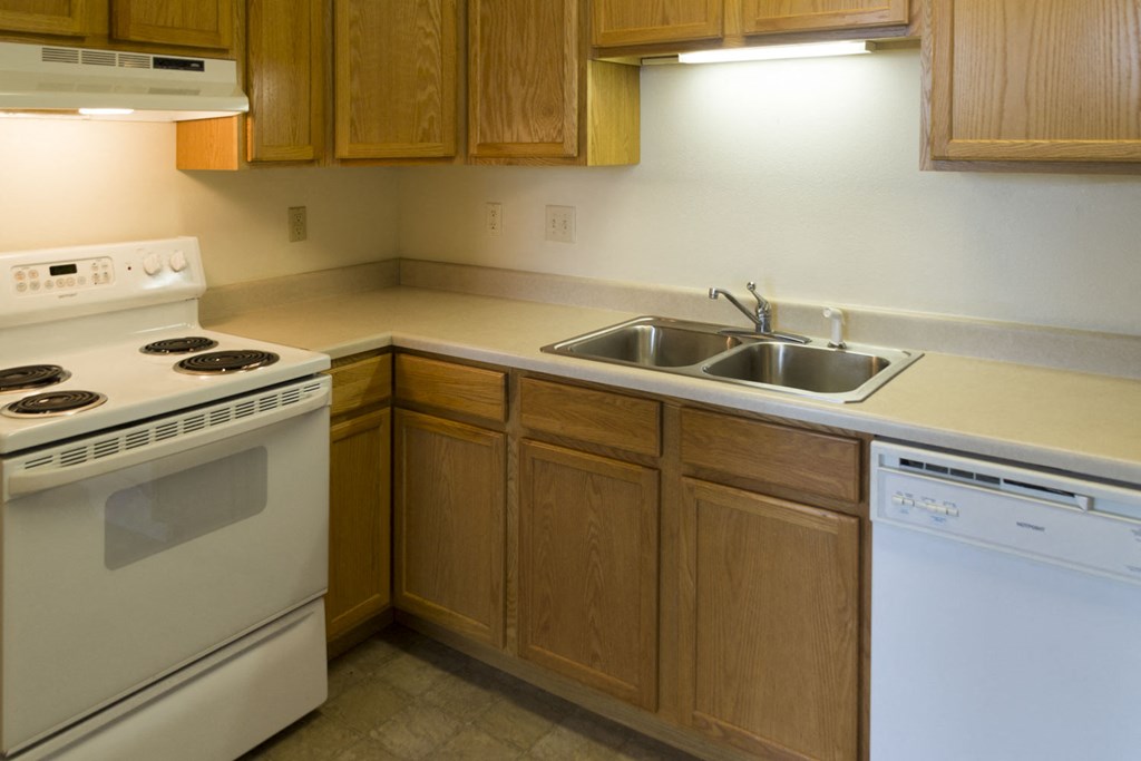 a kitchen with white appliances and wooden cabinets