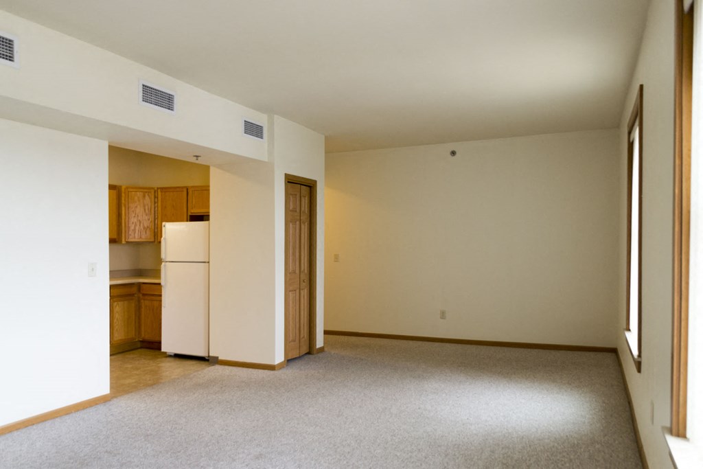 an empty living room with a kitchen in it