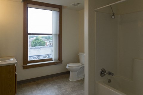 a bathroom with a window and a toilet and a sink