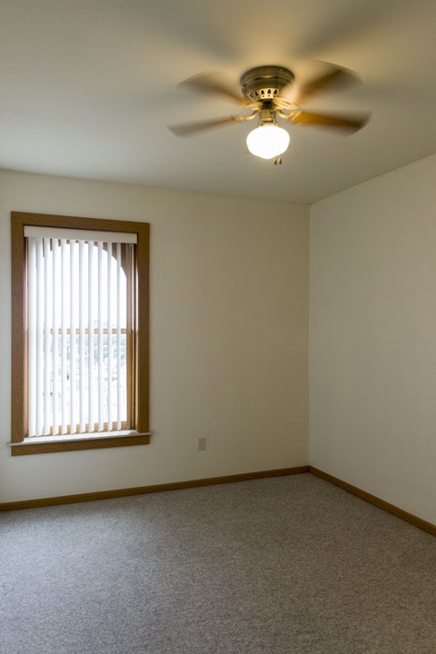 a living room with a ceiling fan and a window