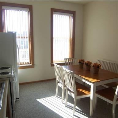 a dining room with a wooden table and chairs