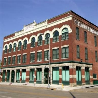 a large red brick building with green doors