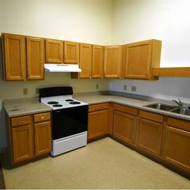 an empty kitchen with a stove and a sink