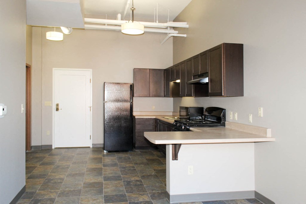 an empty kitchen with a refrigerator and a sink