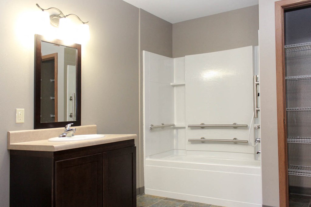 a bathroom with a shower and a sink and a mirror
