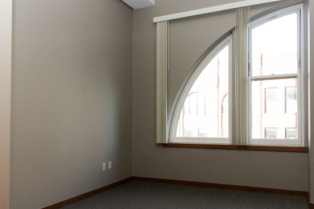 an arched window in the corner of a room