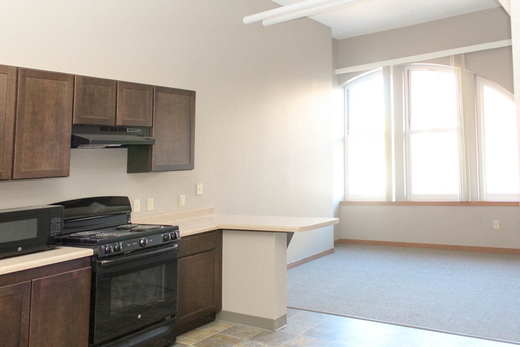 an empty kitchen with a stove and a microwave and