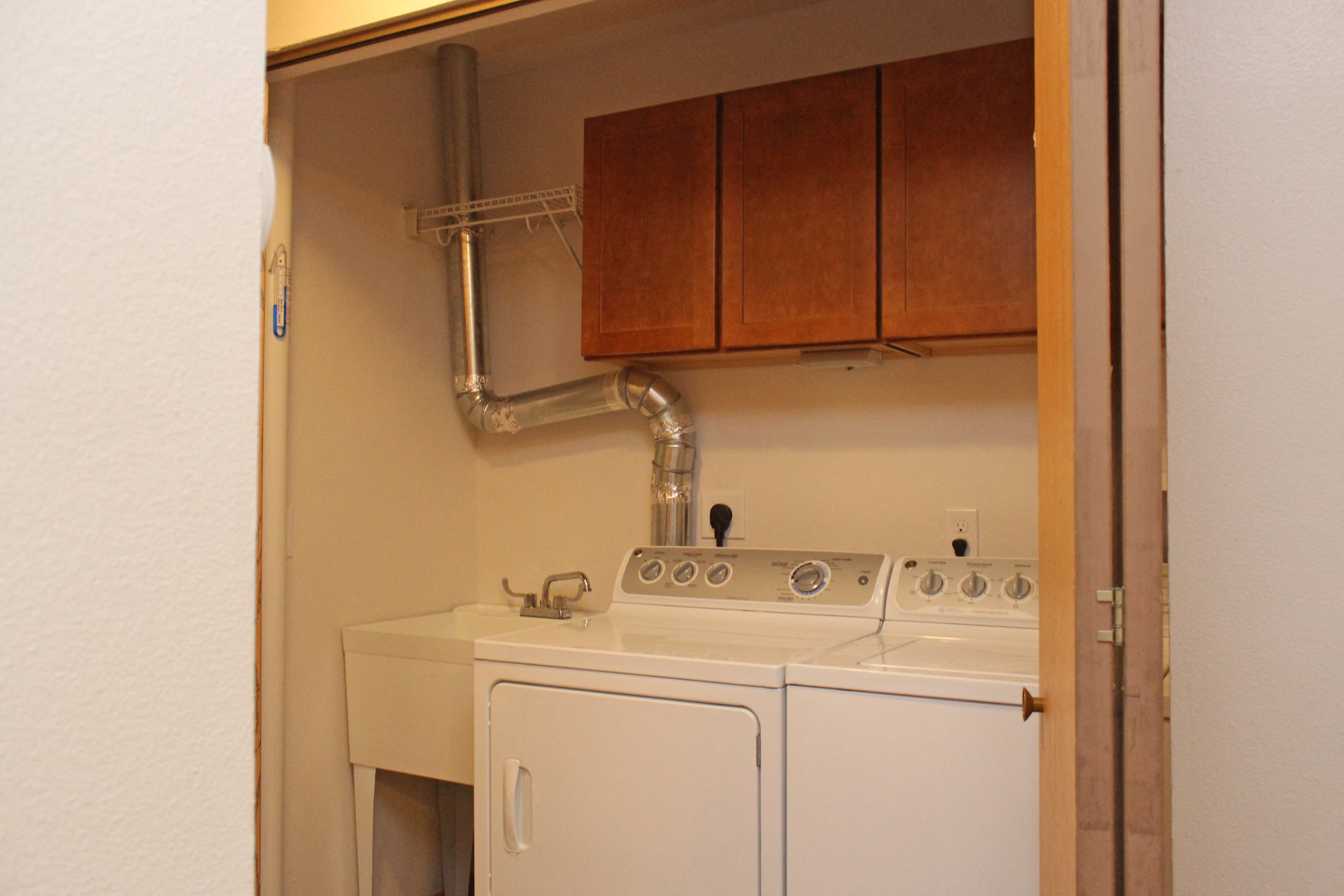 the laundry room has a washer and dryer and cabinets