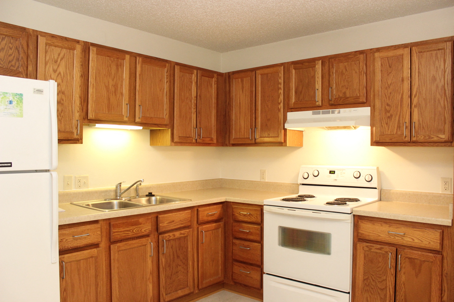 a kitchen with white appliances and wooden cabinets