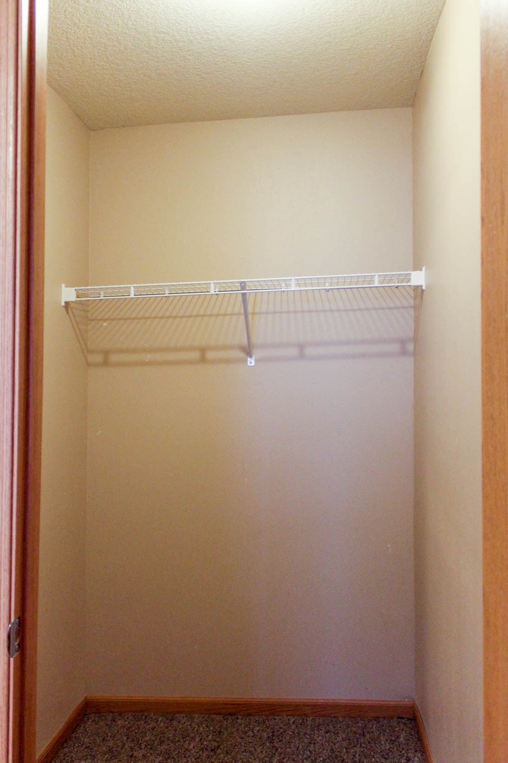 an empty closet with a white shelf in it