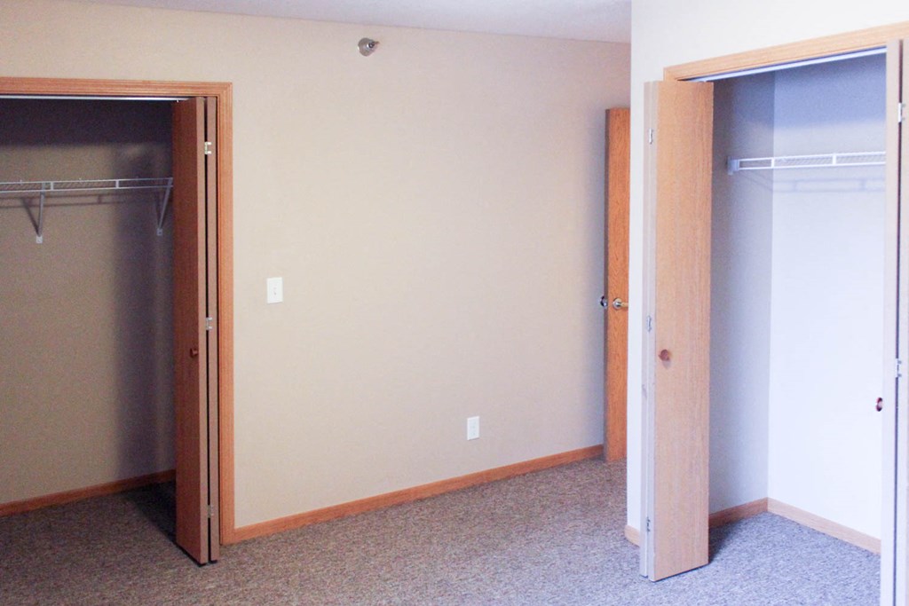an empty room with a closet and an open door