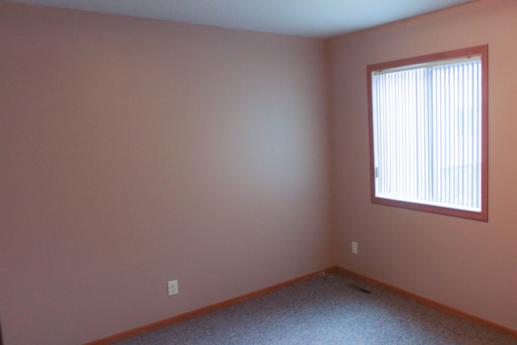 a room with pink walls and a window