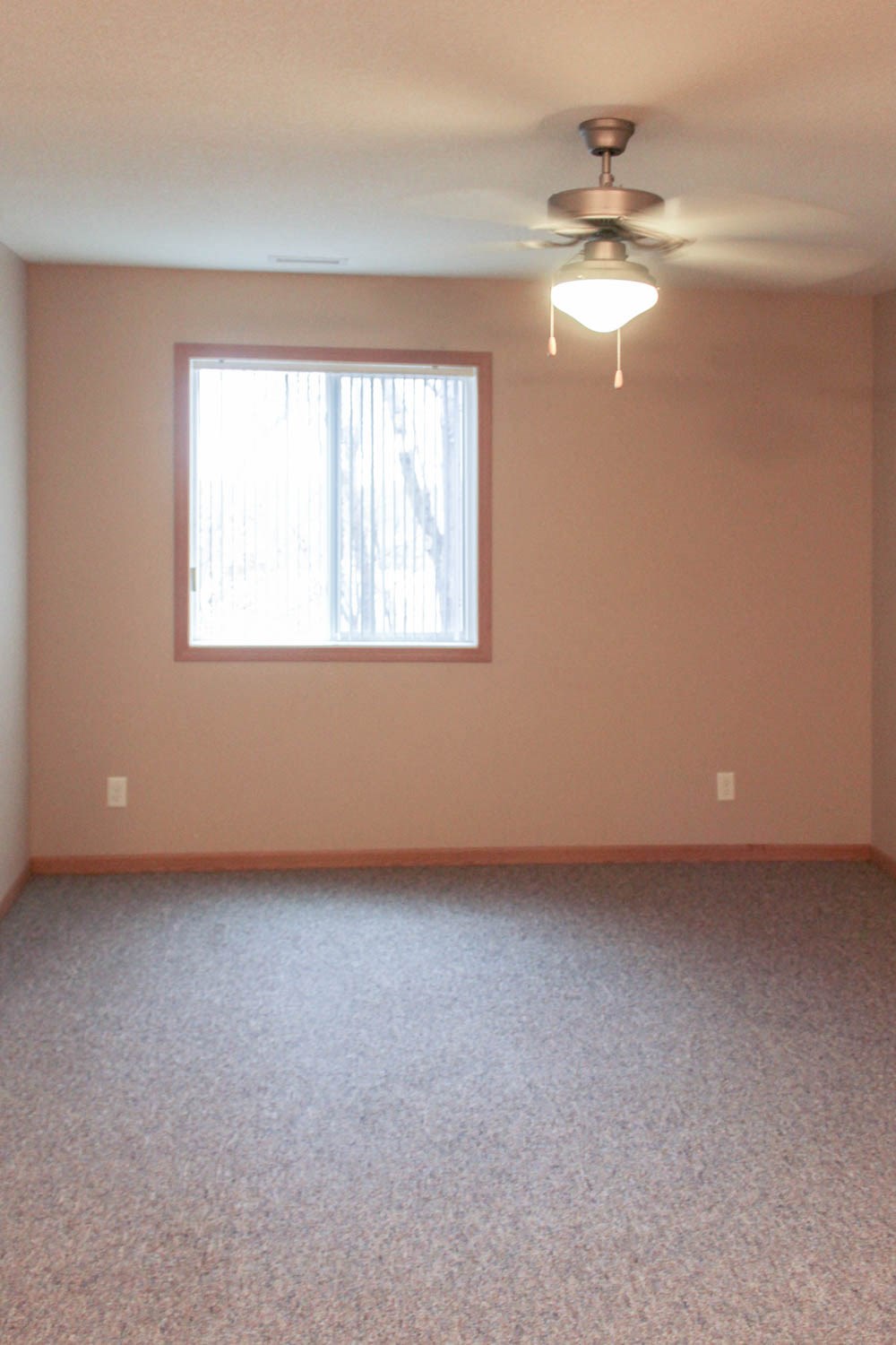 a empty room with a ceiling fan and a window