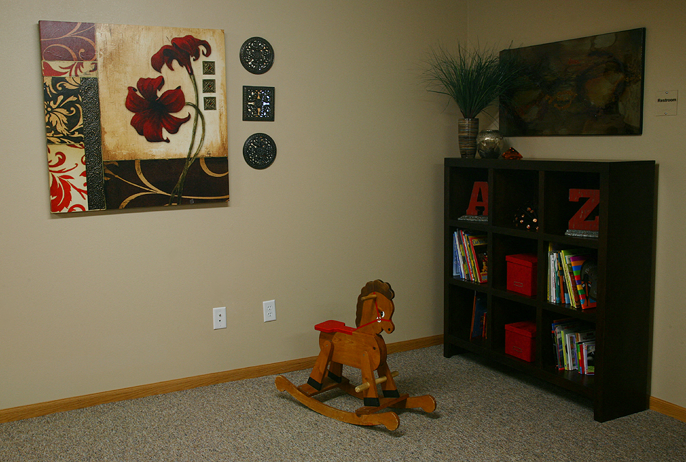 a childs room with a rocking horse and a book shelf