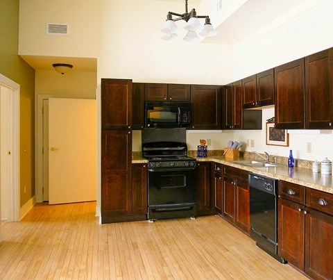 a kitchen with black appliances and wooden cabinets