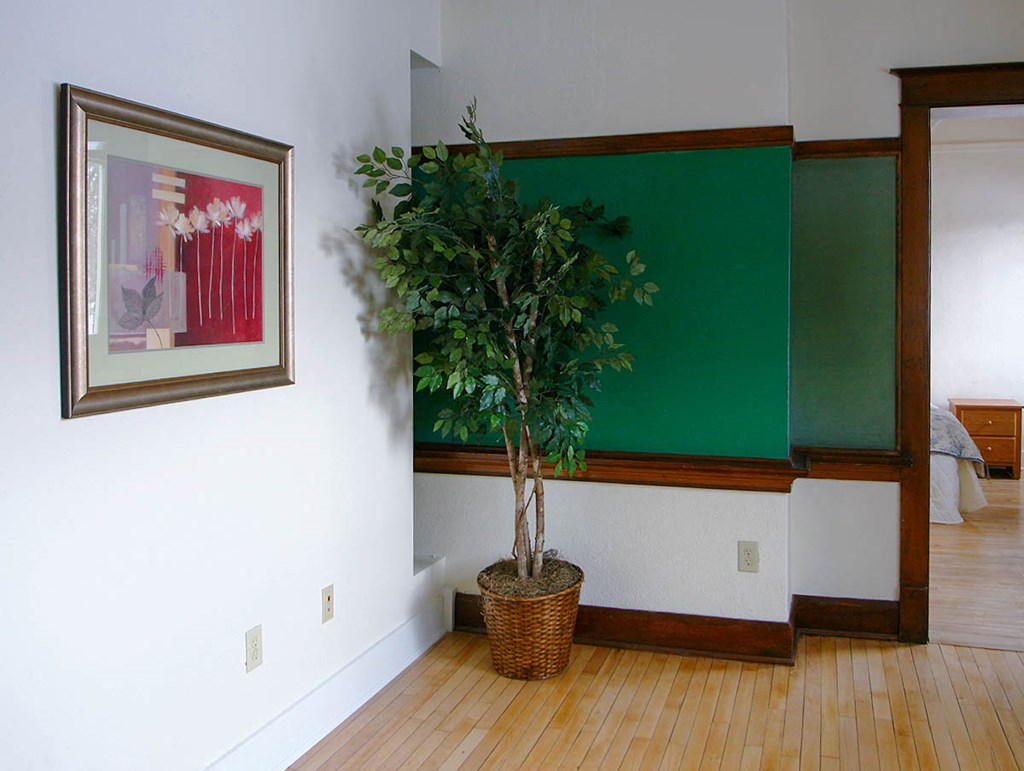 a room with a plant and a painting on the wall