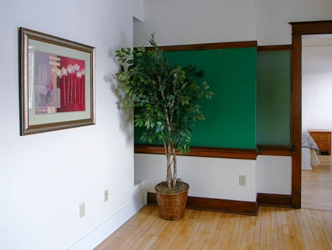 a room with a plant and a painting on the wall