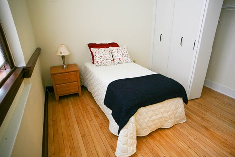 a bedroom with a bed and a wooden floor