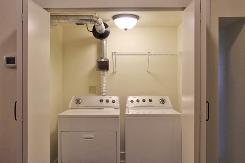 a washer and dryer in a room with a light above them