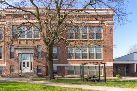 a large brick building with a picnic table in front of it