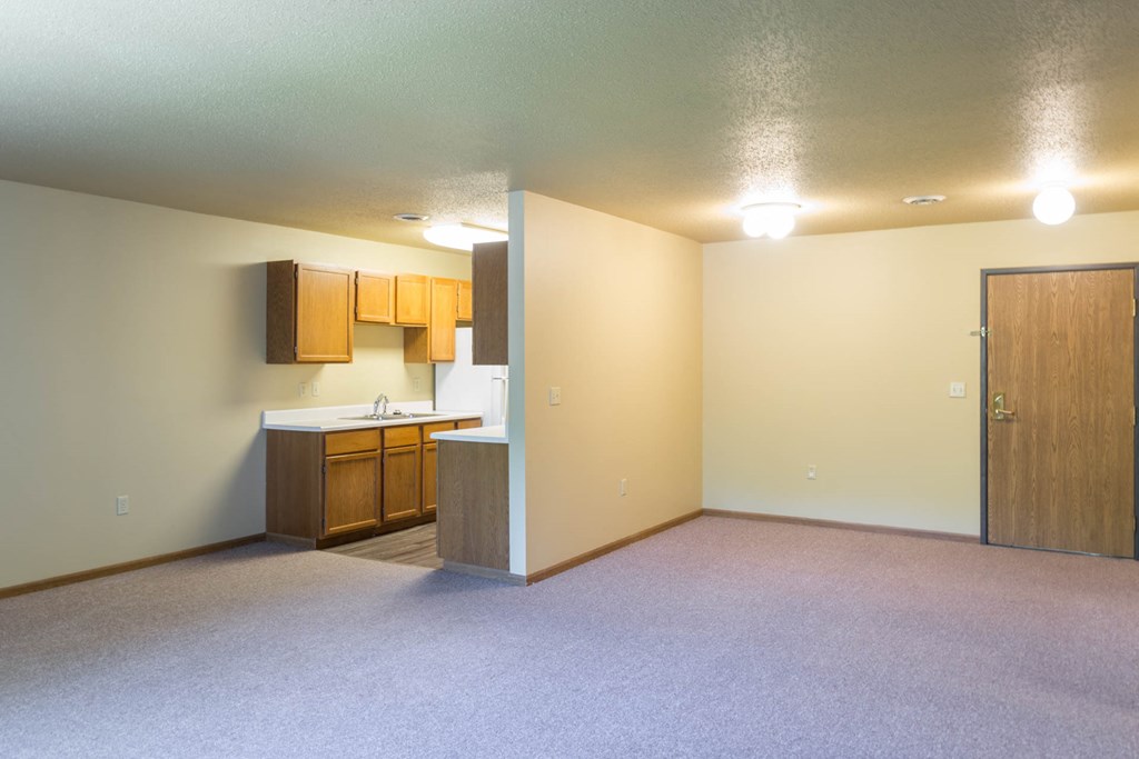 a empty living room with a kitchen in it