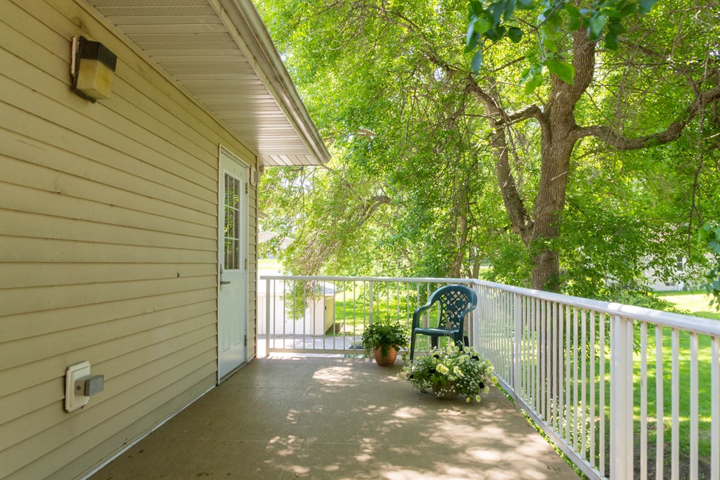 the front porch of a house with a bench on it
