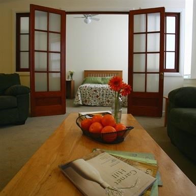 a living room with a bowl of oranges on a table