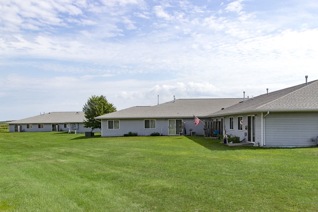 a row of houses with a grassy yard in front of them