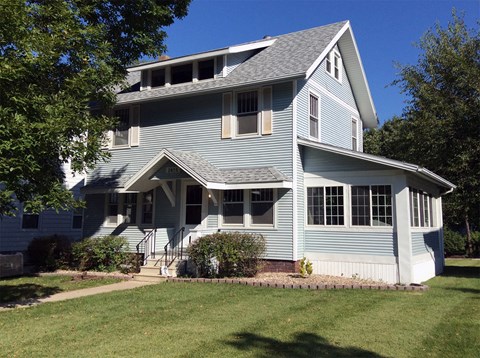 a blue house with a lawn in front of it