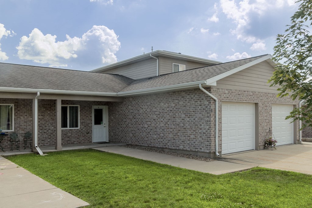 a brick house with a white garage door and a lawn